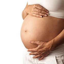 Zwangerschapsklachten - twee handen houden zwangere buik vast